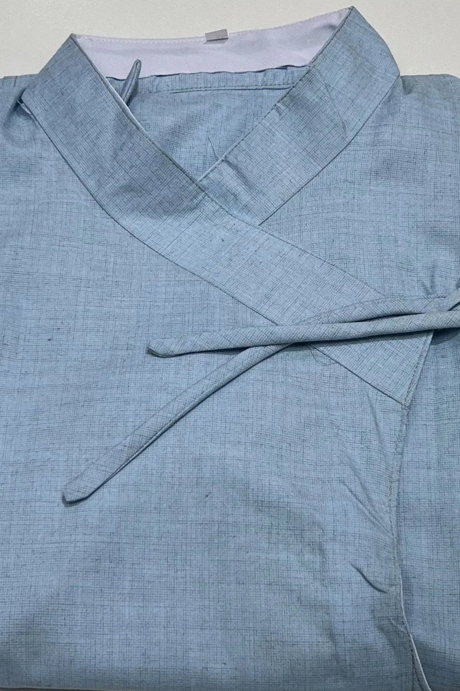 Folded light blue shirt on a white background