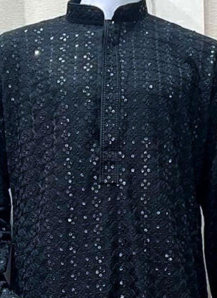 A mannequin displaying a black kurta set with sequin work and a diamond cut pattern, also wearing white pyjama trousers.